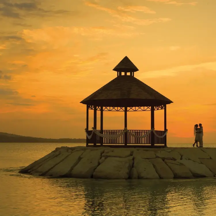 Silhouette of a couple by the oceanfront gazebo at Secrets Wild Orchid, Montego Bay during sunset