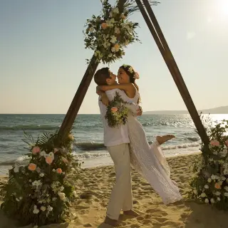 Groom lifting bride in front of a triangle floral arch at Secrets Wild Orchid, Montego Bay