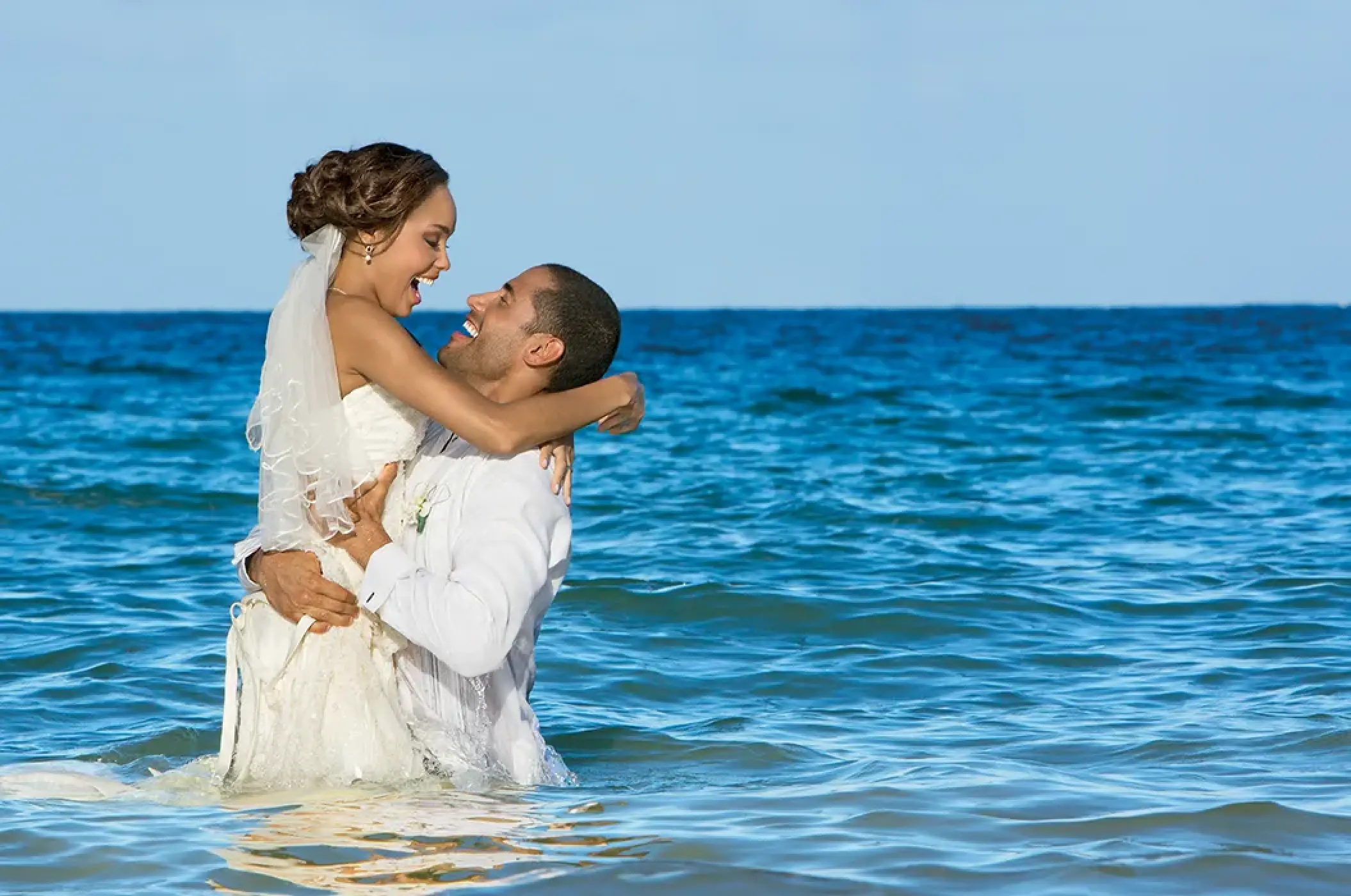 Groom lifting the bride in the ocean at Secrets Wild Orchid, Jamaica