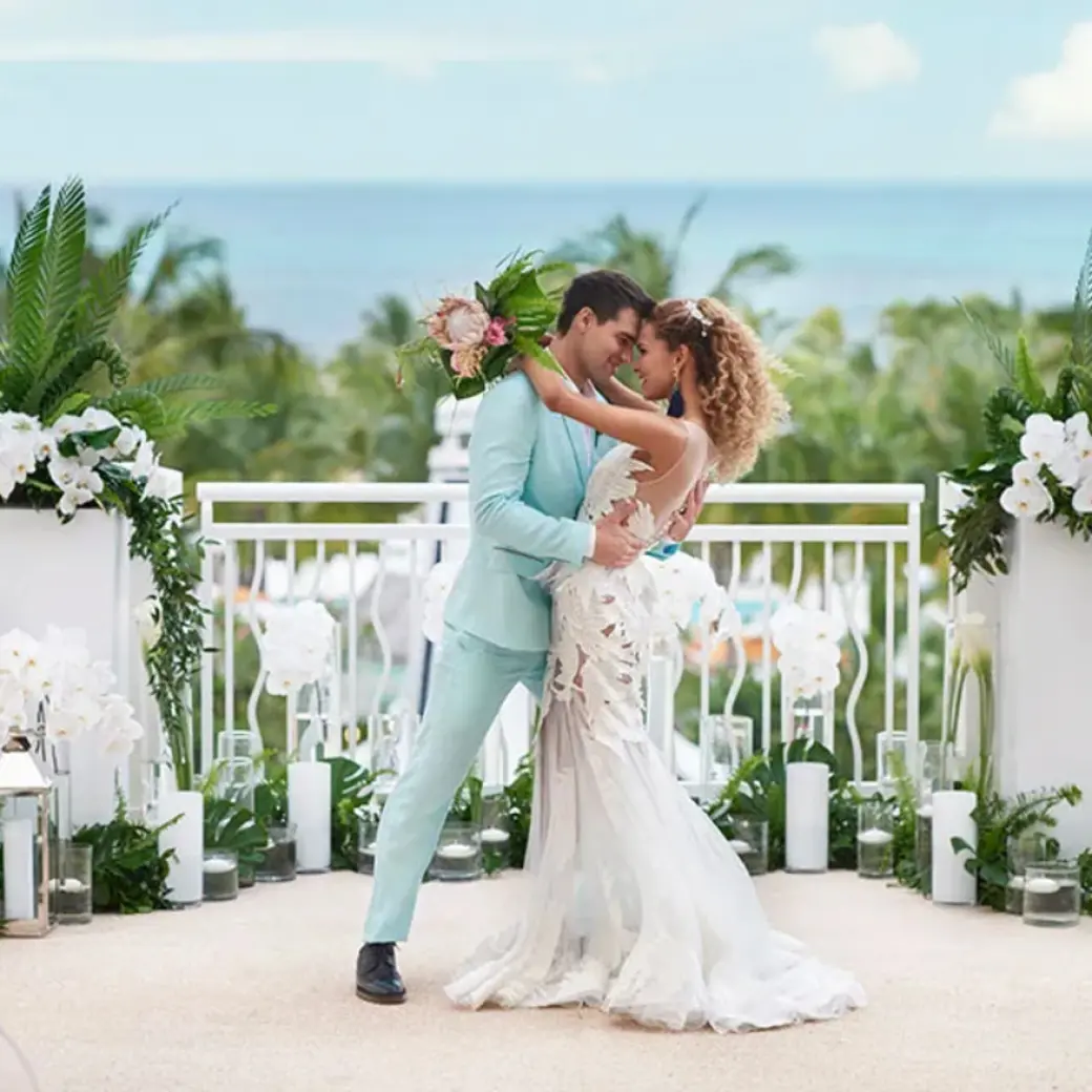 The bride and groom posing during a rooftop wedding ceremony at SLS Playa Mujeres, Cancun