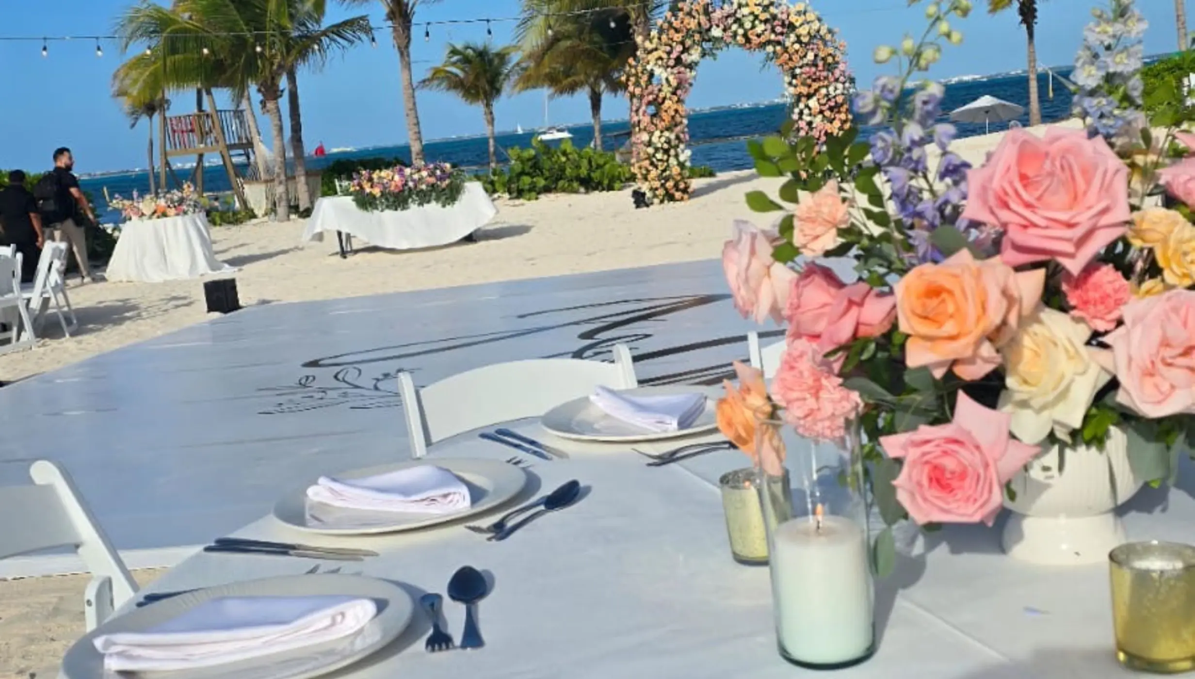 Beachfront wedding reception table with floral centerpiece at SLS Playa Mujeres, Cancun