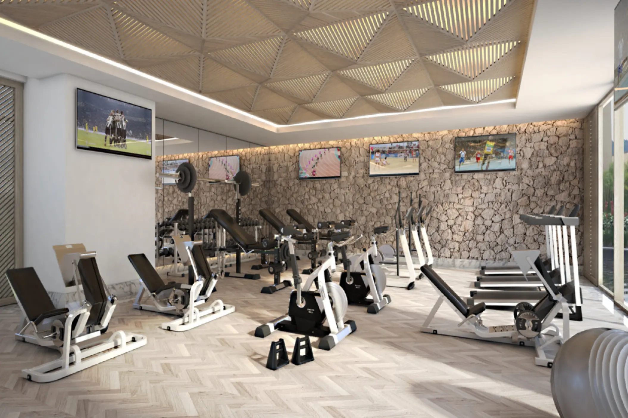Modern fitness center with workout equipment and textured stone walls at SLS Playa Mujeres, Cancun