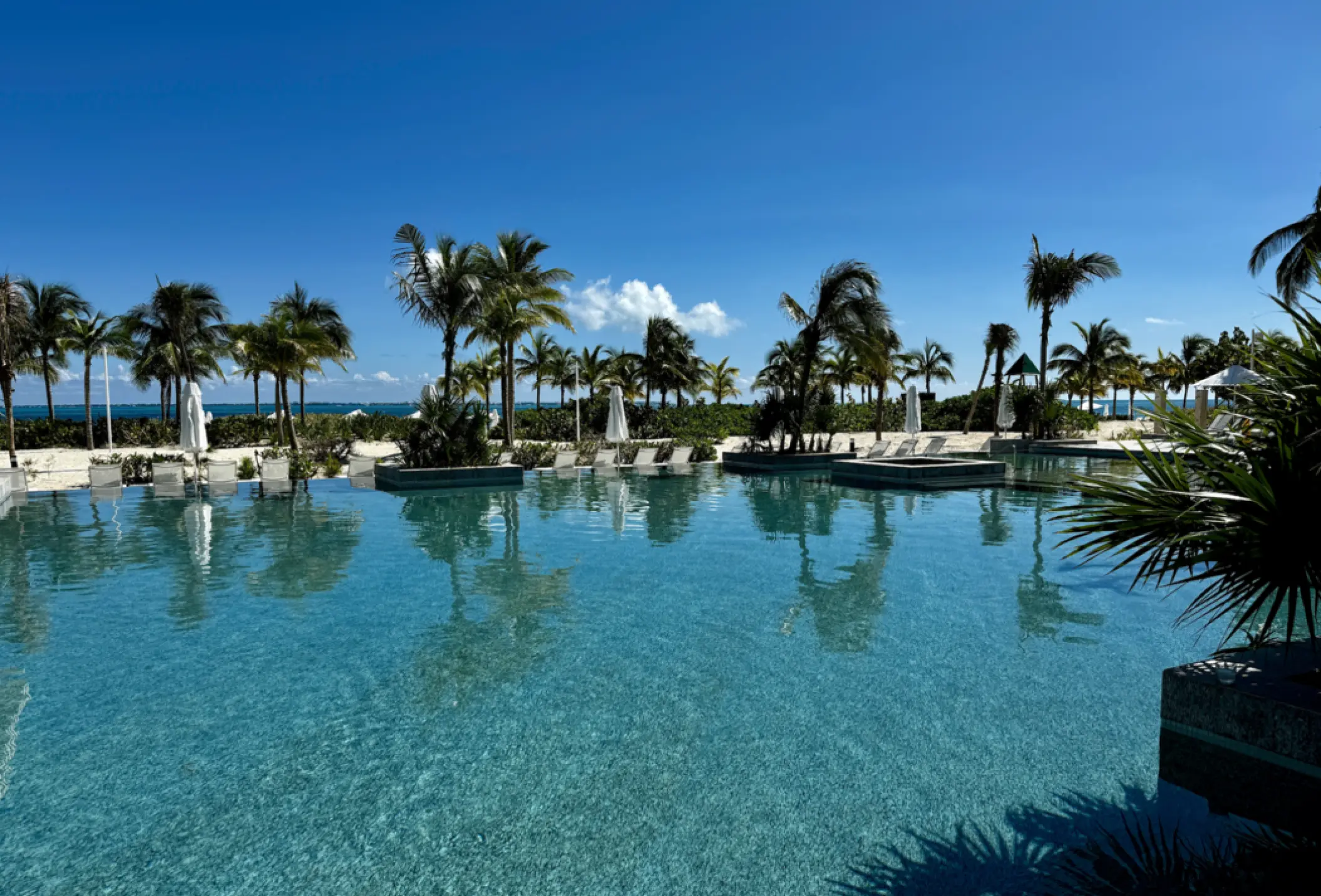 Main swimming pool surrounded by palm trees at SLS Playa Mujeres, Cancun