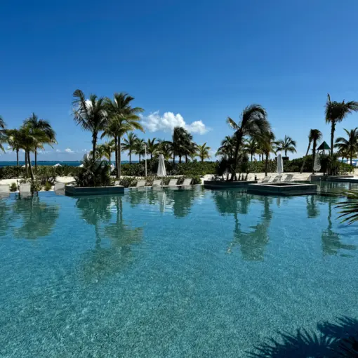 Main swimming pool surrounded by palm trees at SLS Playa Mujeres, Cancun