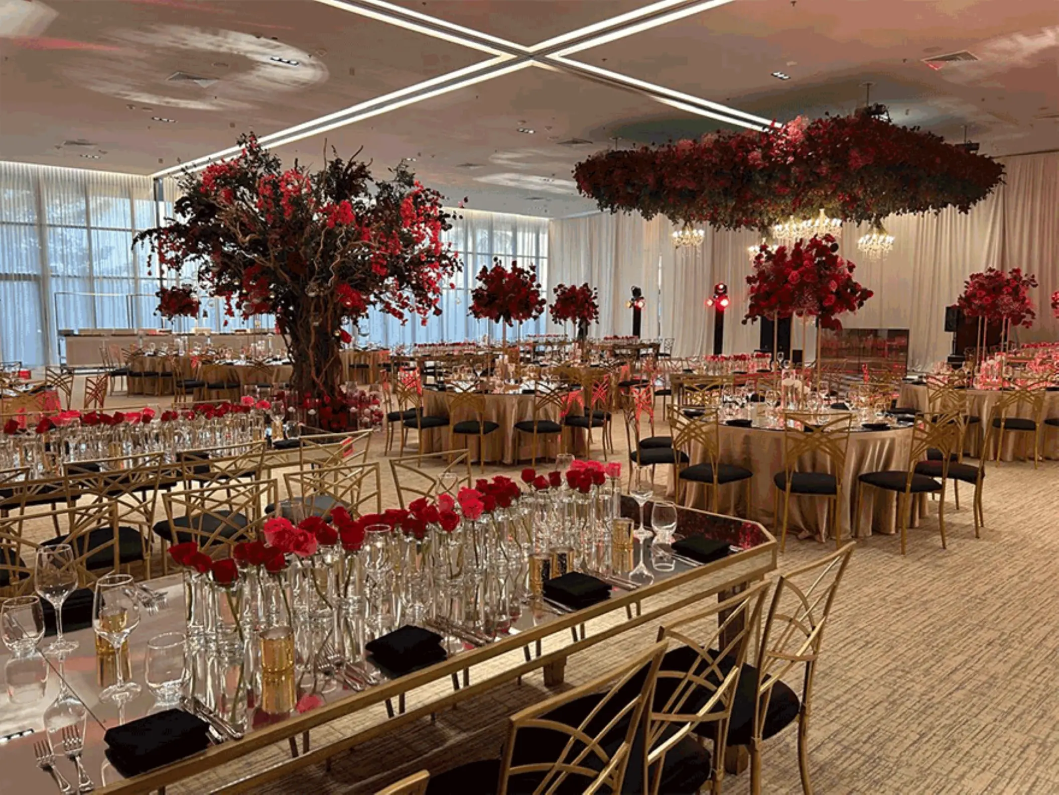 Grand Ballroom wedding reception setup with red floral centerpieces at SLS Playa Mujeres, Cancun