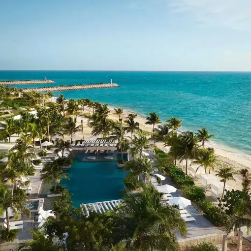 SLS Playa Mujeres swimming pool and beachfront palm trees overlooking the ocean, Cancun