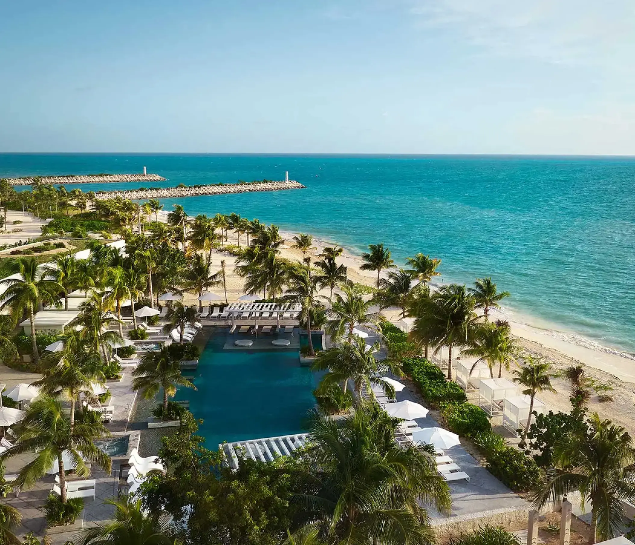 SLS Playa Mujeres swimming pool and beachfront palm trees overlooking the ocean, Cancun