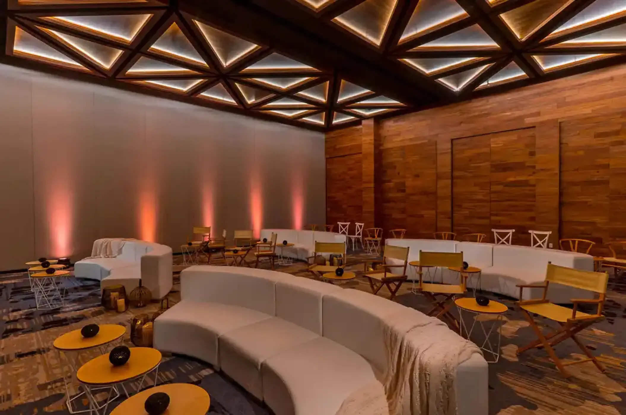 Indoor reception lounge with geometric ceiling lights and wooden walls at Solaz Los Cabos, Cabo San Lucas