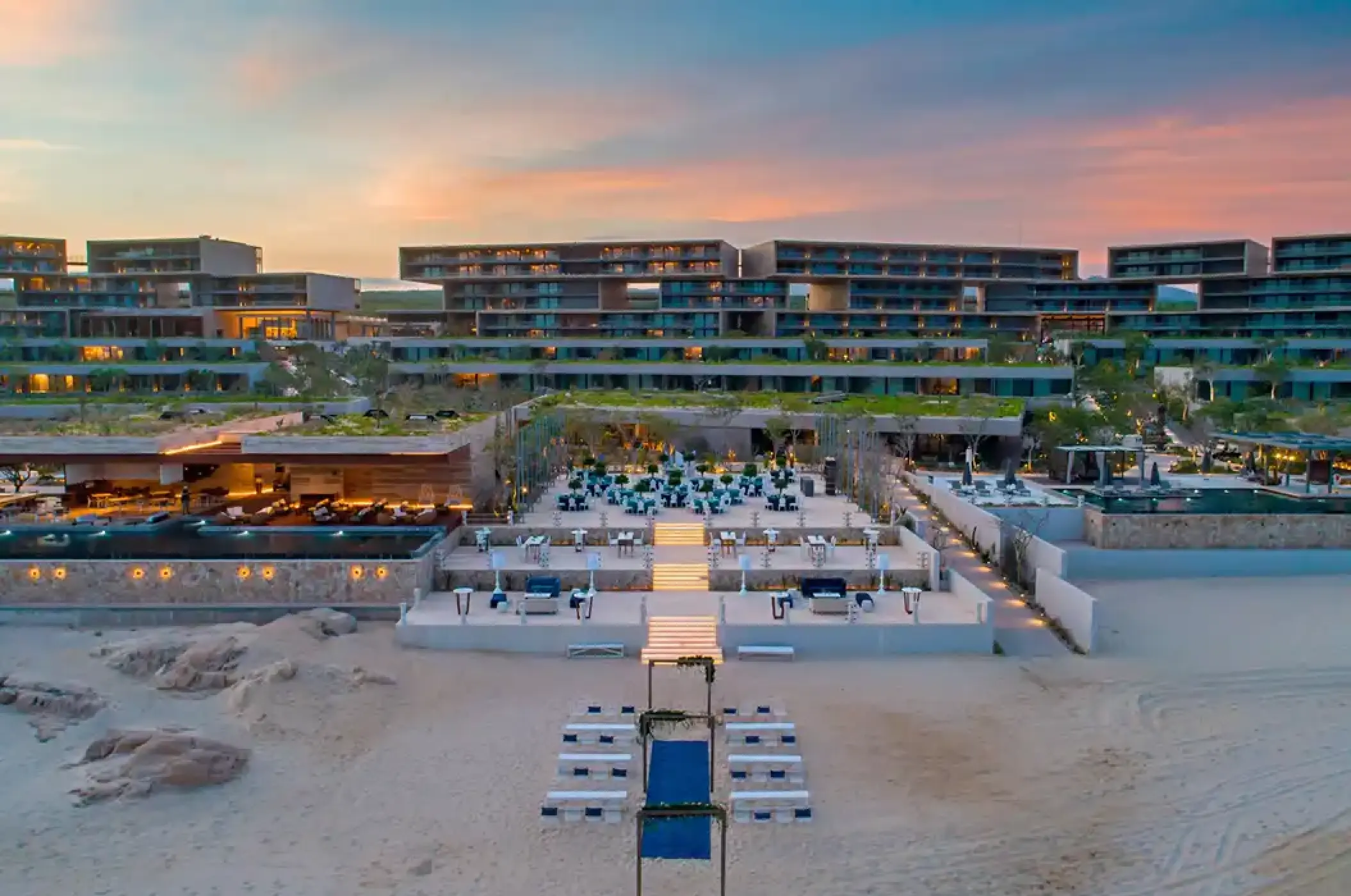 Aerial view of the modern beachfront exterior and tiered terraces at Solaz Los Cabos, Cabo San Lucas