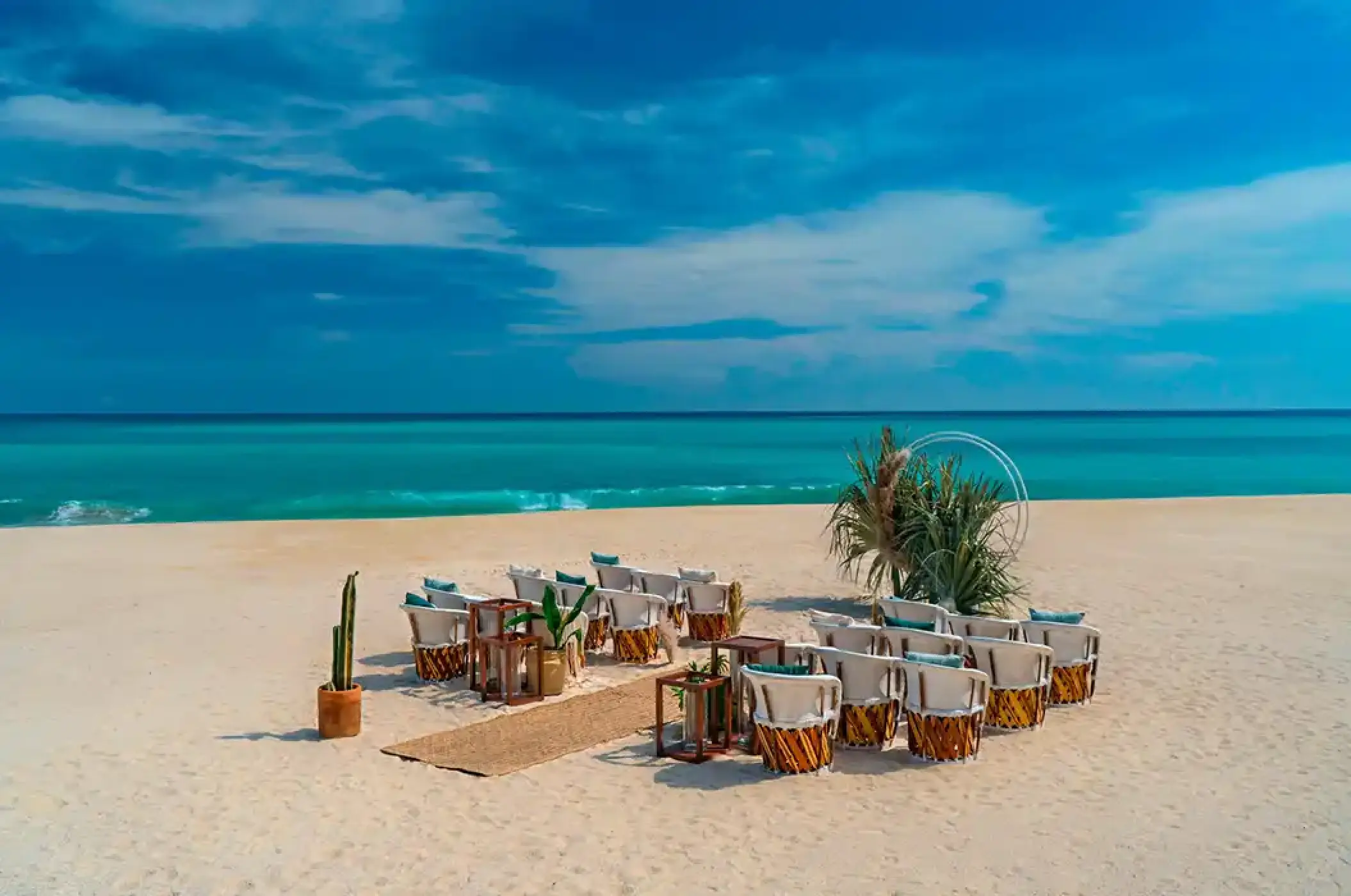 Beach wedding ceremony setup with circular arch at Solaz Los Cabos, Cabo San Lucas
