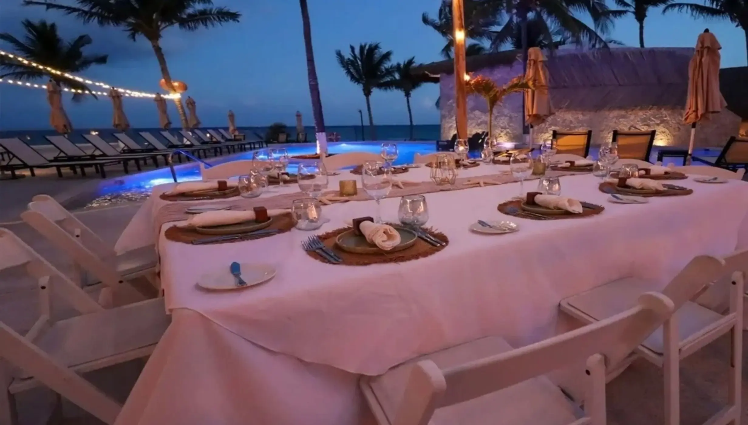 Outdoor wedding reception table setup under string lights at The Beachfront by The Fives, Playa Del Carmen