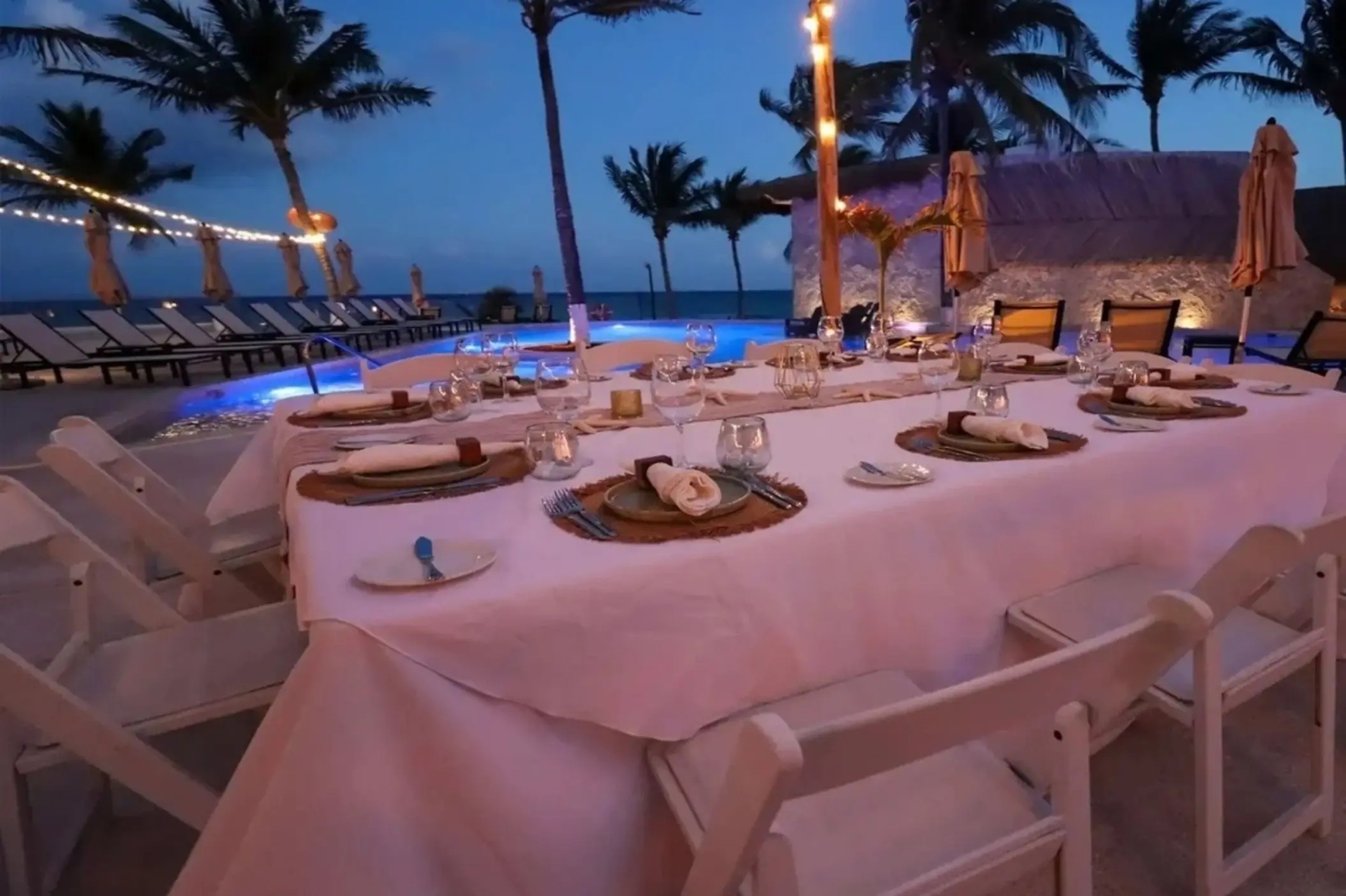 Outdoor wedding reception table setup under string lights at The Beachfront by The Fives, Playa Del Carmen