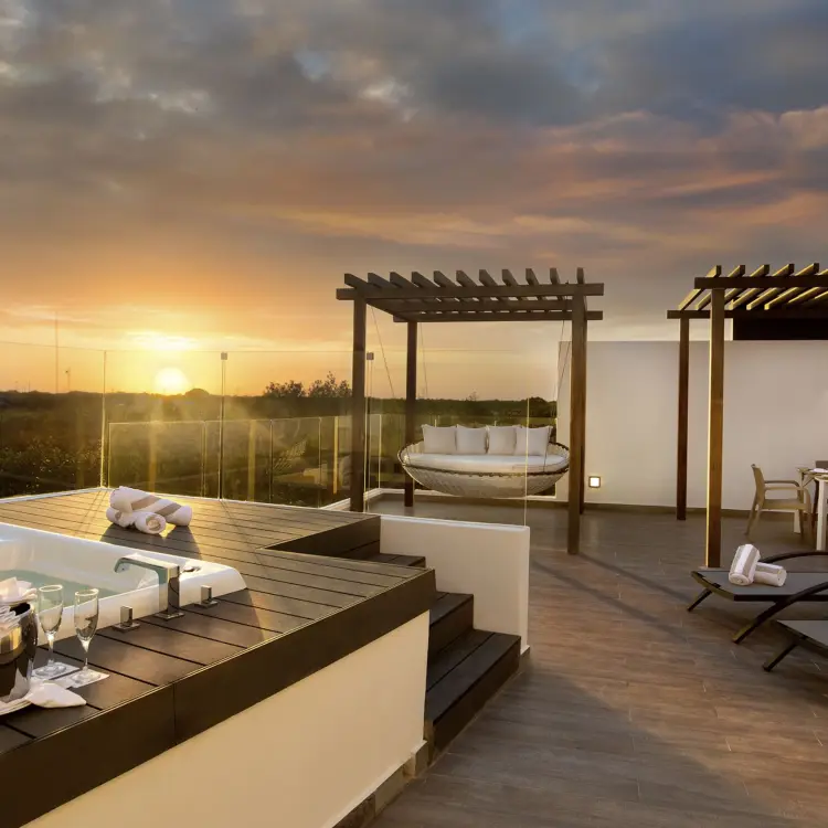 Penthouse terrace with a private hot tub and lounge seating at sunset at The Fives Beach Hotel, Playa Del Carmen