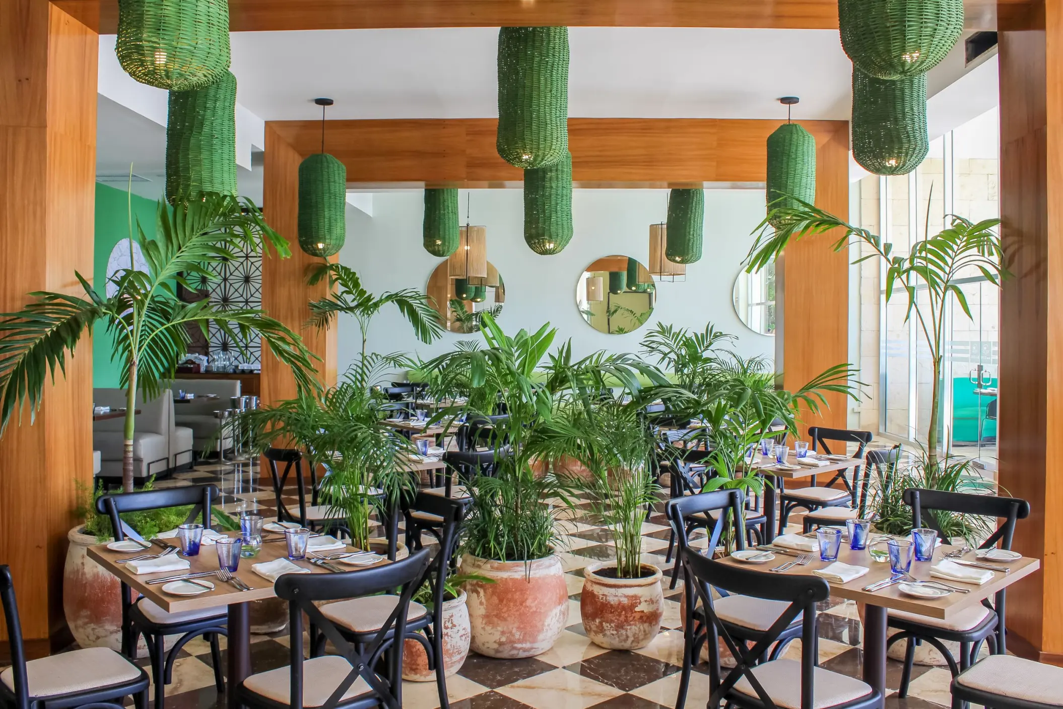 Sea Olive restaurant interior with green lanterns and potted plants at The Fives Beach Hotel, Playa Del Carmen