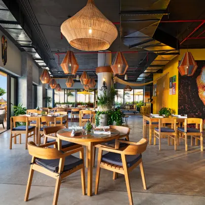 RoMarley restaurant reception venue with wooden tables and woven light fixtures at The Fives Oceanfront, Riviera Maya
