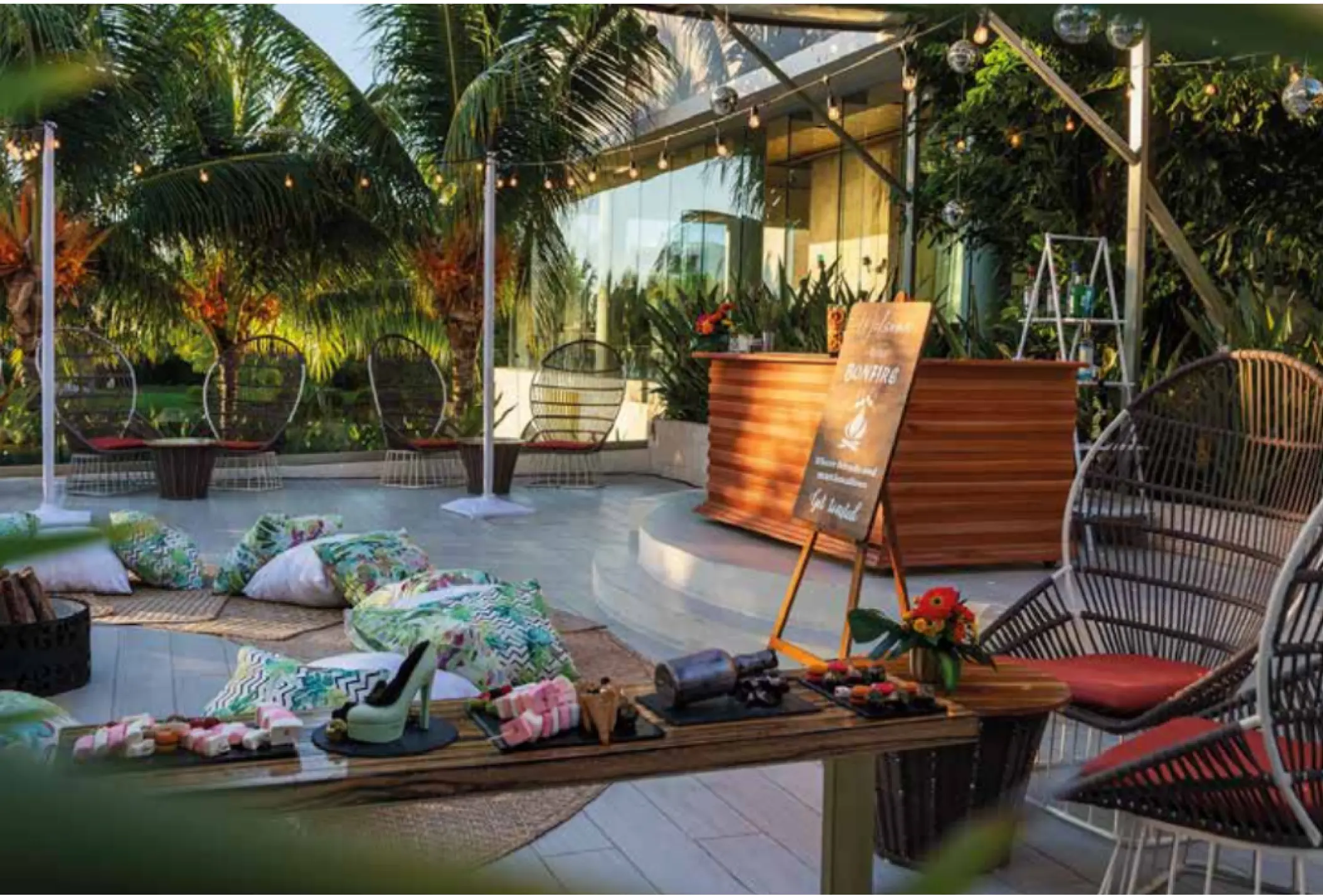 Aurum Terrace lounge with string lights and floor cushions for a wedding reception at TRS Coral, Cancun