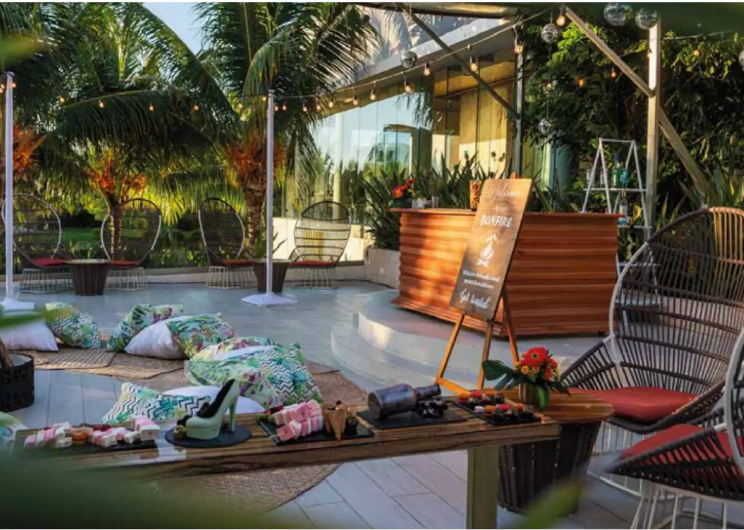 Aurum Terrace lounge with string lights and floor cushions for a wedding reception at TRS Coral, Cancun