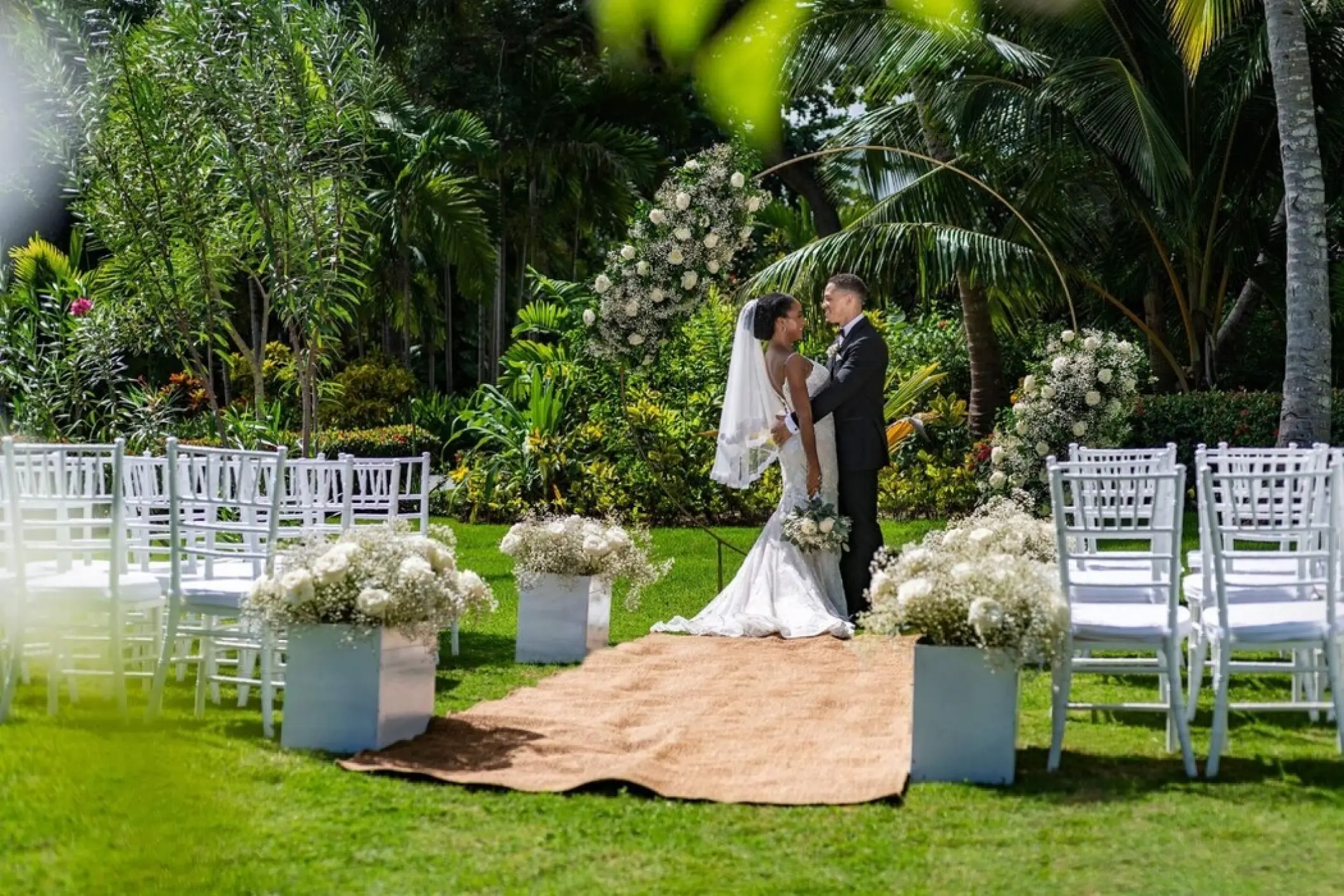 Bride and groom standing at a garden wedding ceremony at TRS Turquesa, Punta Cana