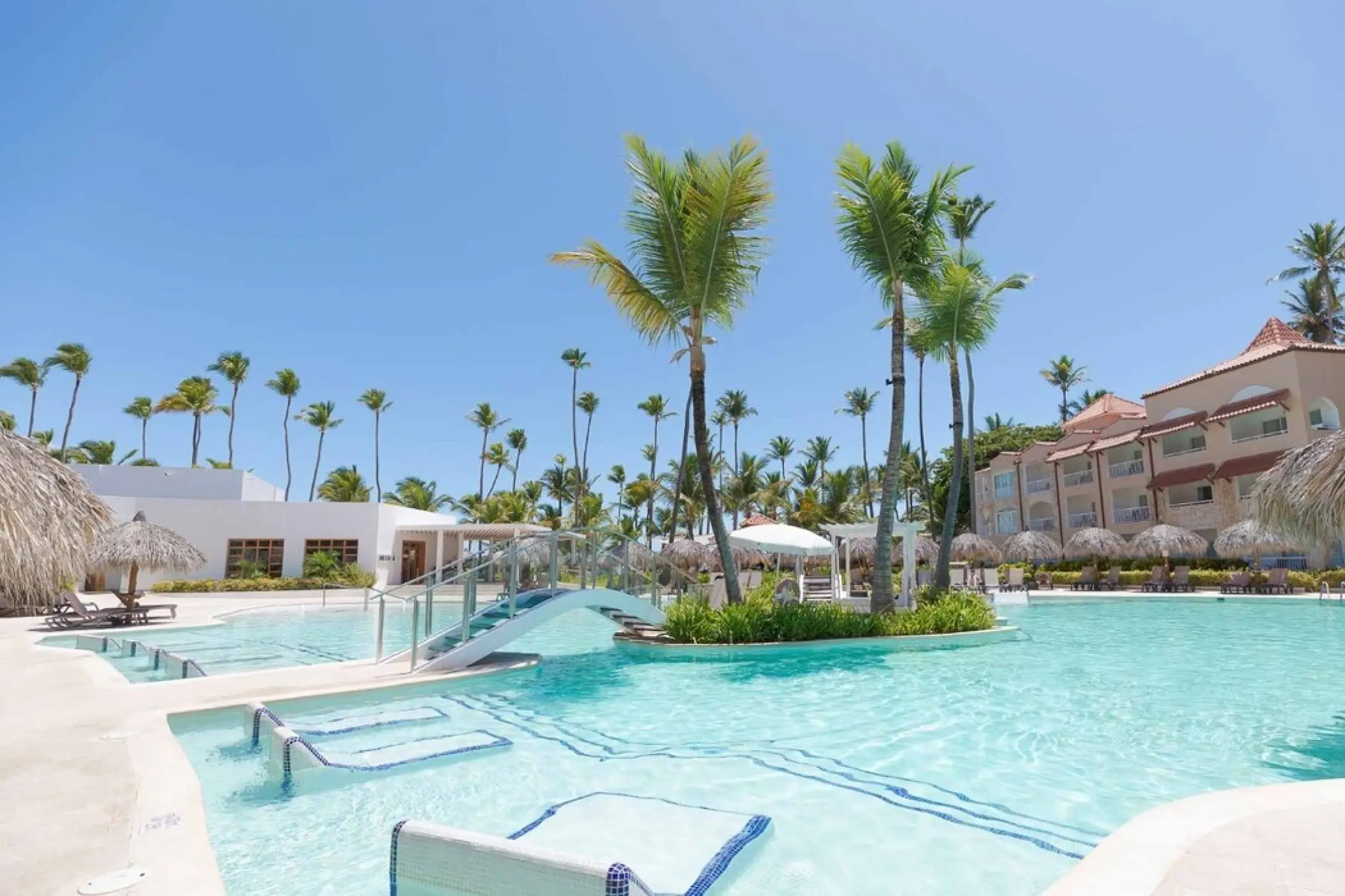 TRS Turquesa main swimming pool with in-water loungers and palm trees, Punta Cana