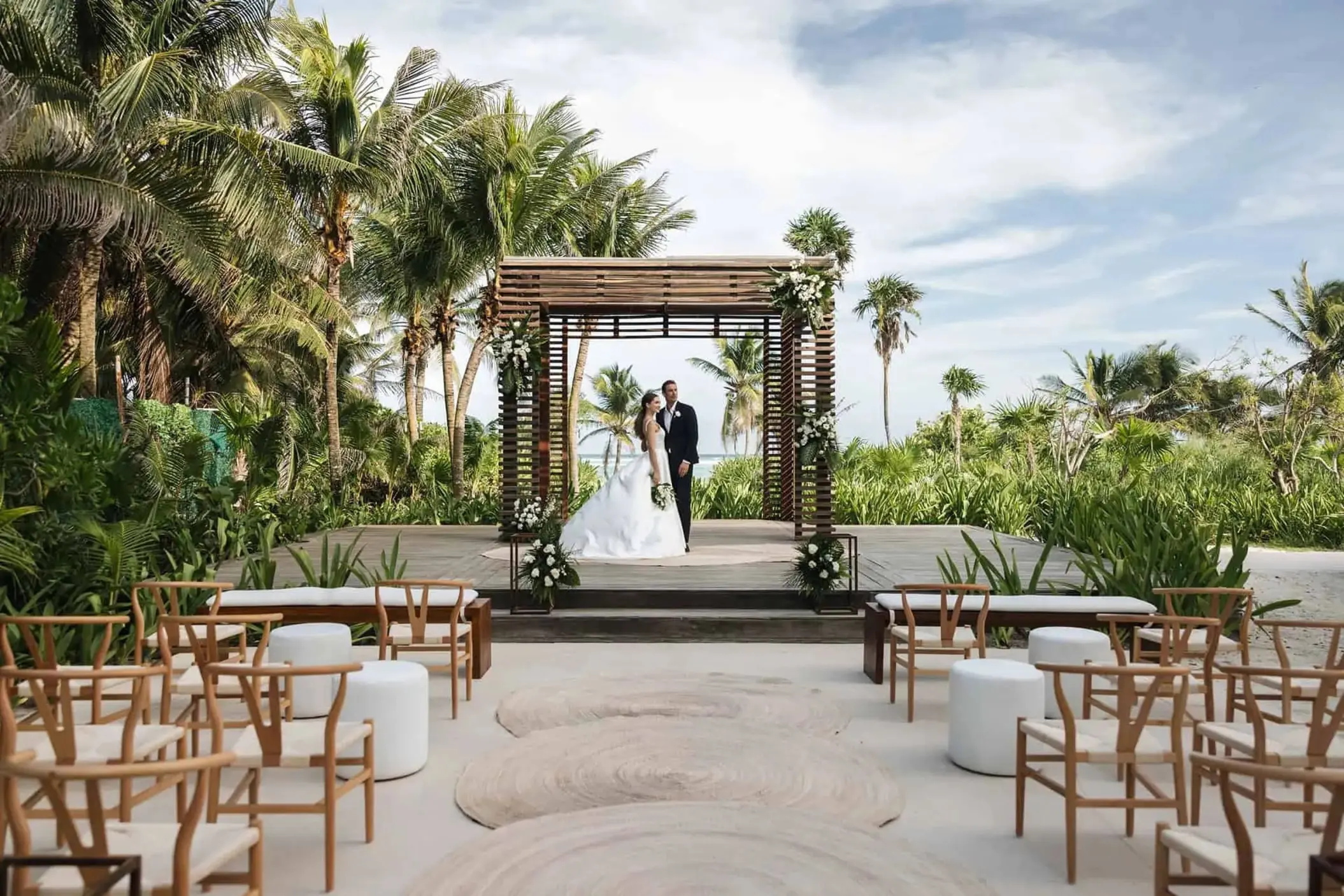 The bride and groom under a wooden gazebo for a wedding ceremony at UNICO 20°87°, Riviera Maya