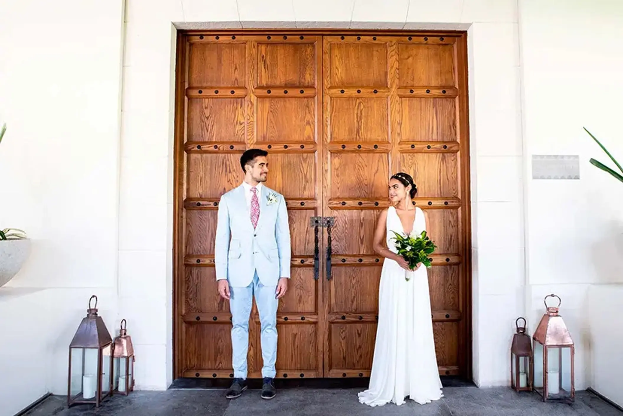 Bride and groom posing in front of large wooden doors at UNICO 20°87°, Riviera Maya