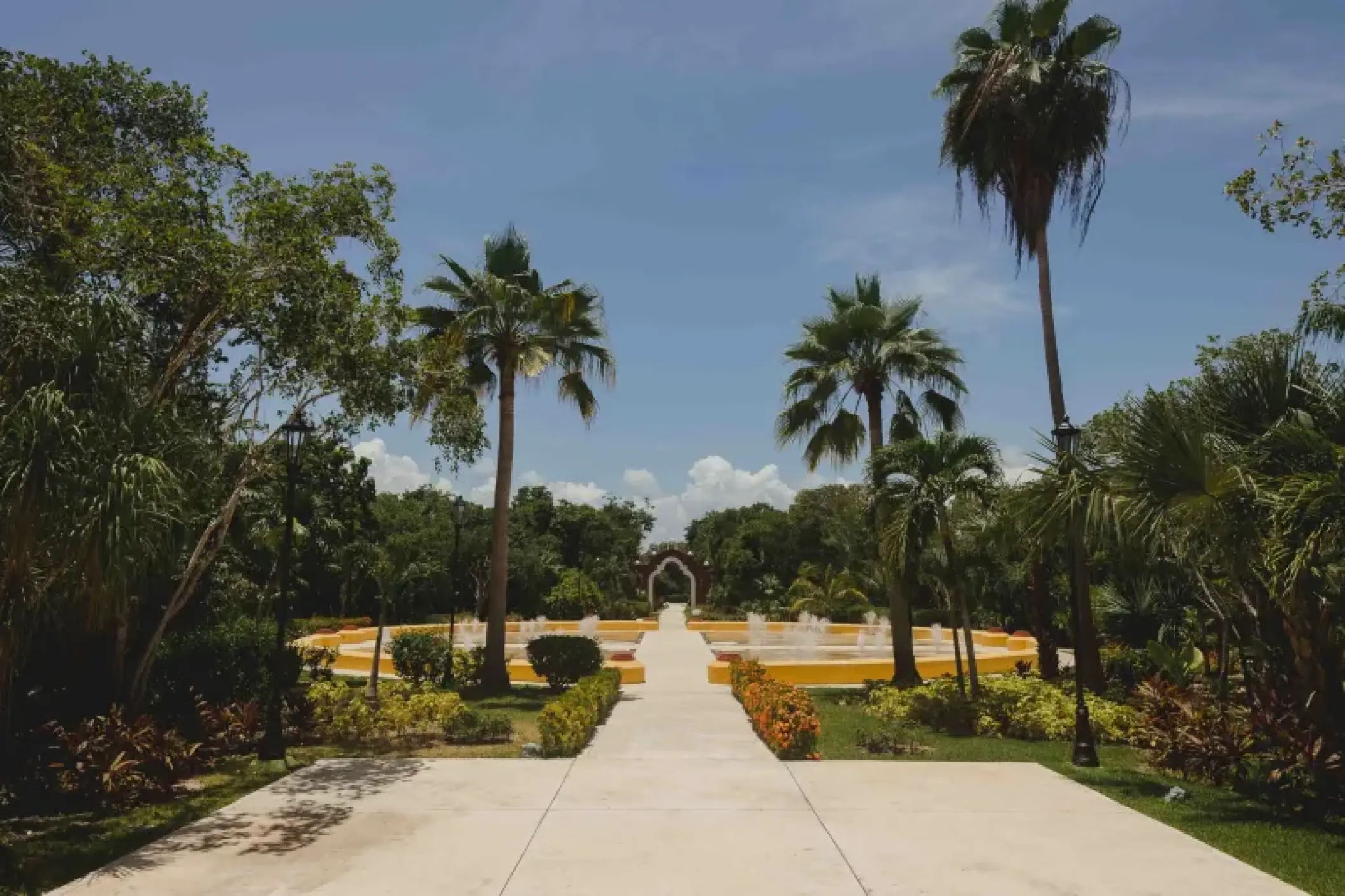 Palm-lined walkway leading to a fountain plaza at Valentin Imperial, Riviera Maya