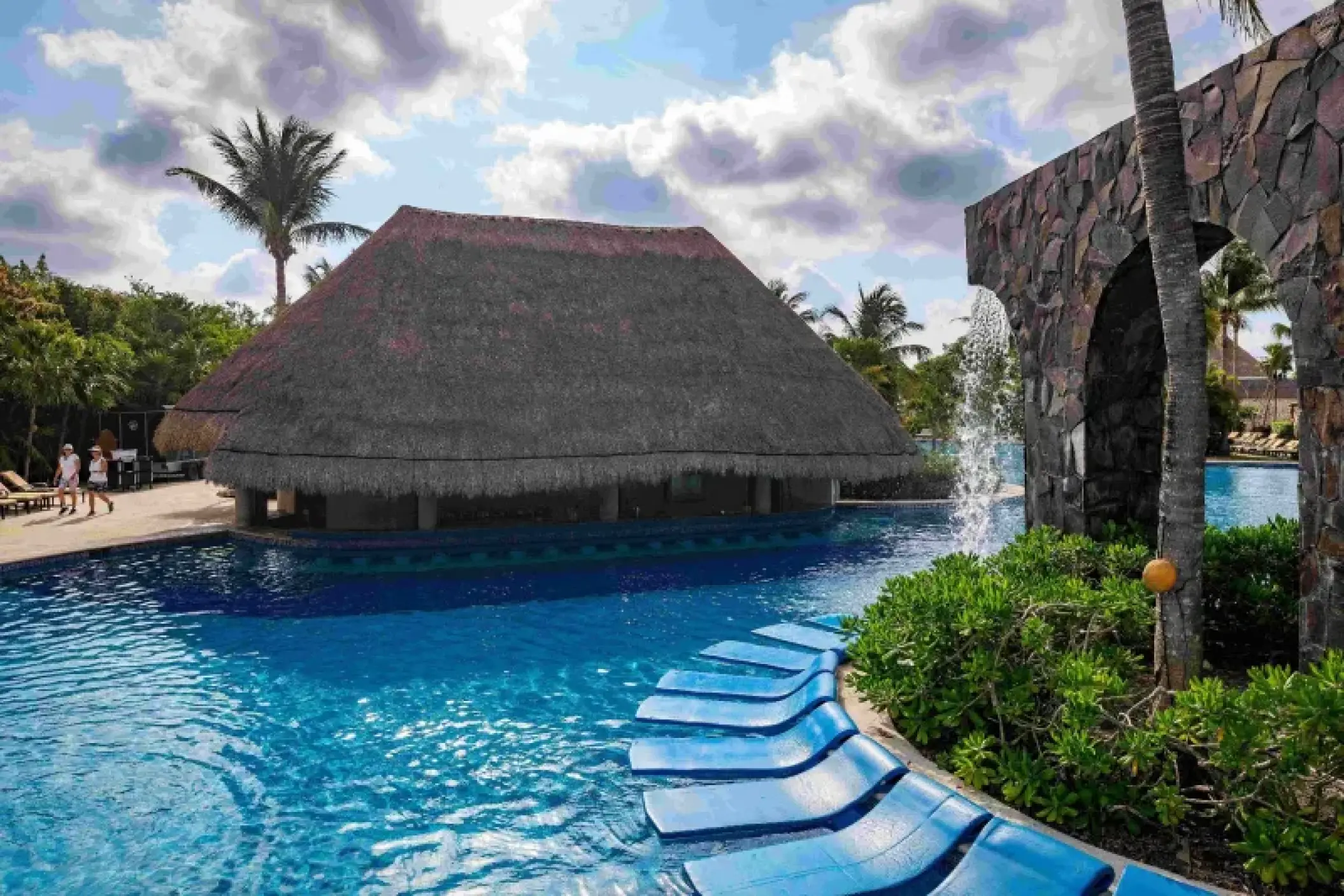 Valentin Imperial Riviera Maya swim-up bar and pool area with lounge chairs and stone waterfall