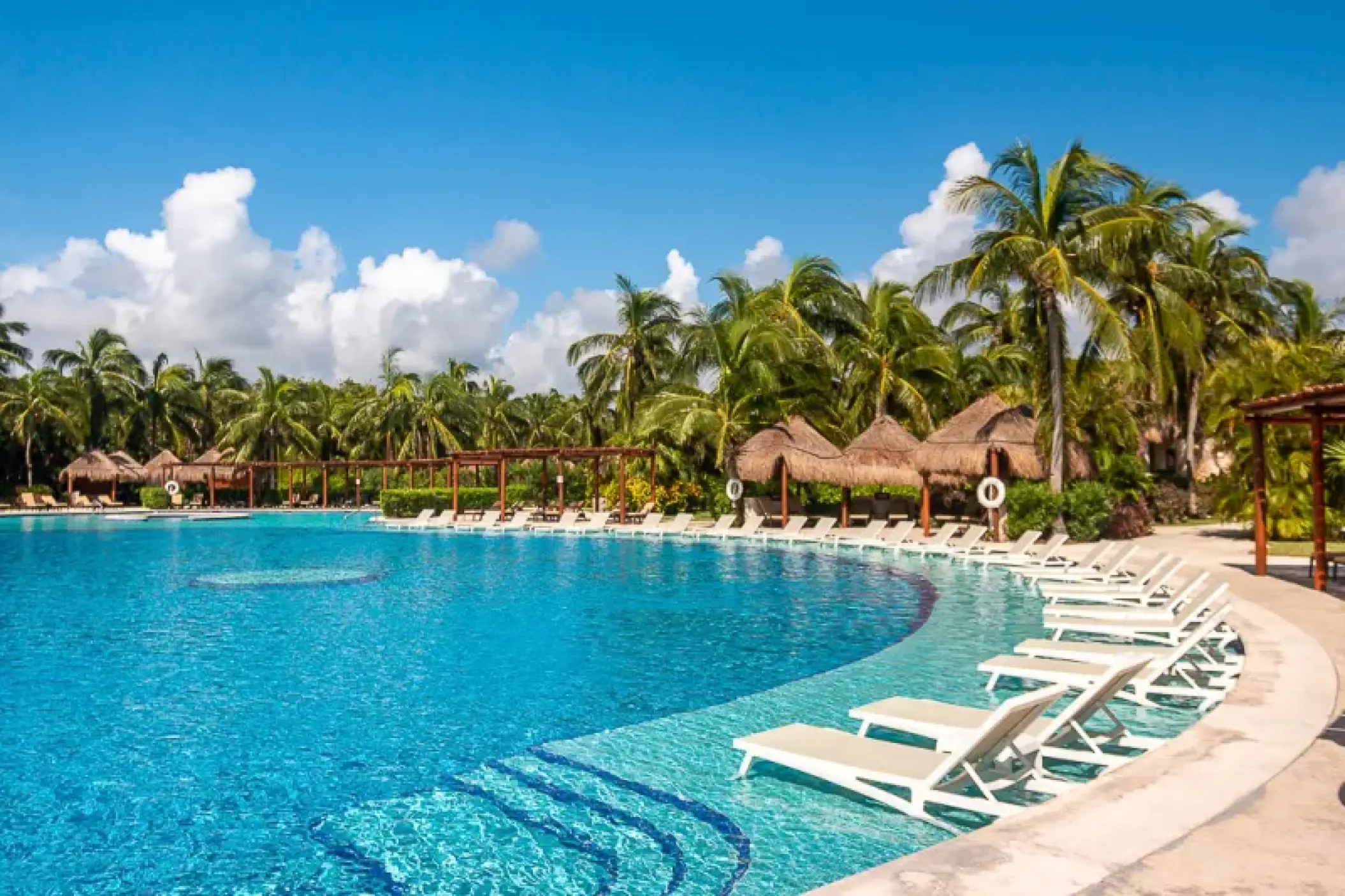 Valentin Imperial Riviera Maya curved pool with submerged loungers and tropical palm trees