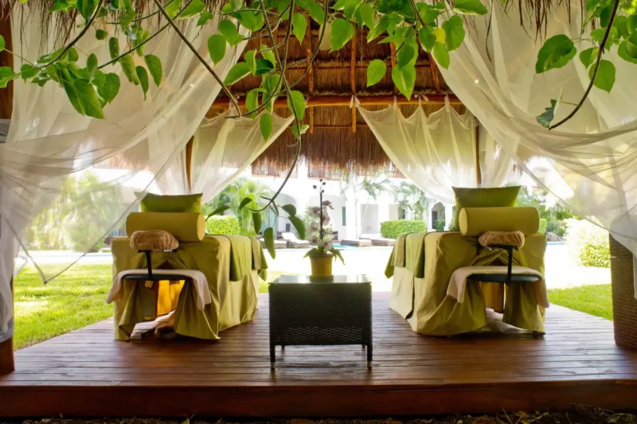 Outdoor spa treatment tables under a thatched palapa at Valentin Imperial, Riviera Maya