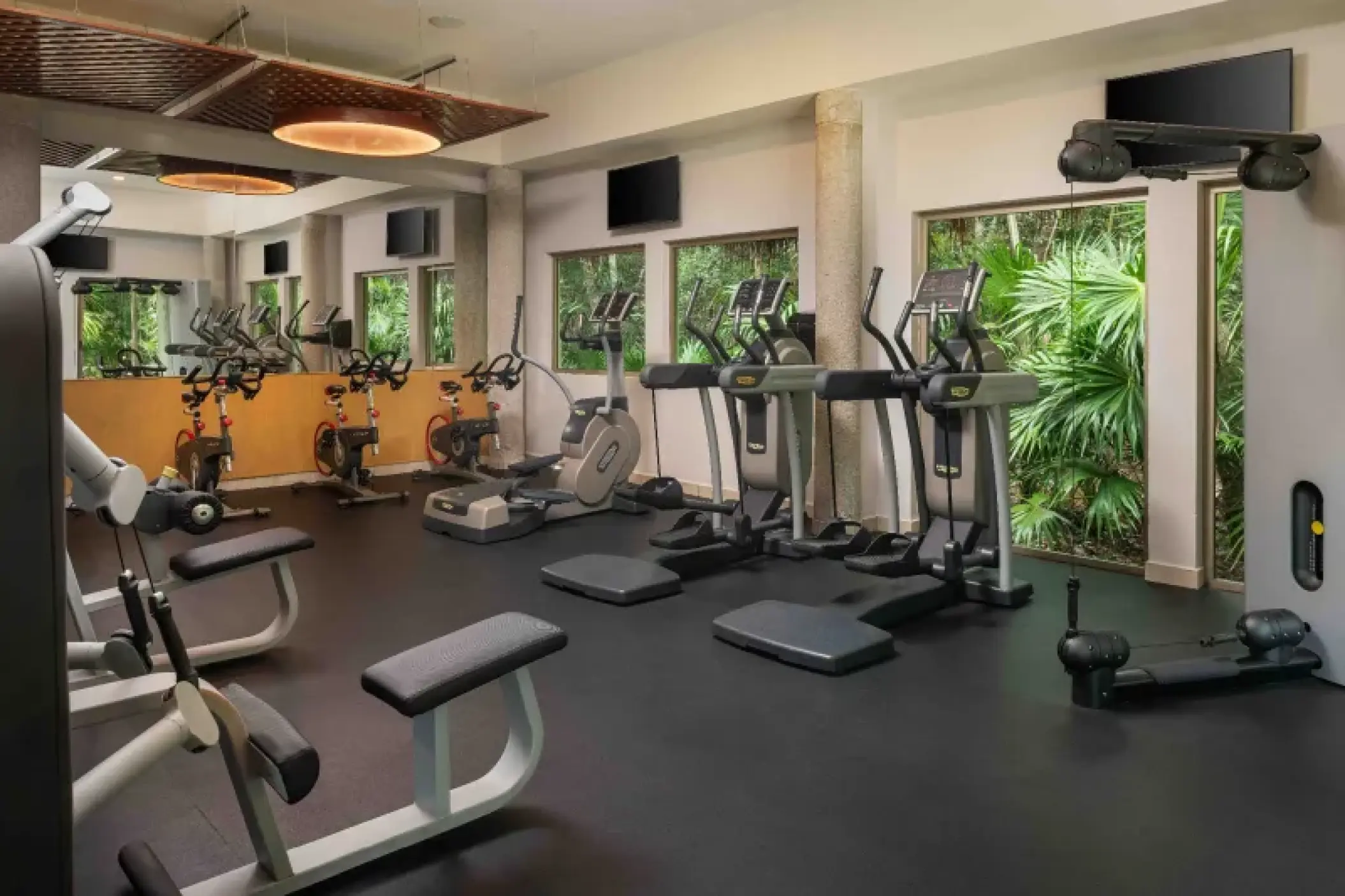 Valentin Imperial fitness center with cardio machines and windows looking out to tropical greenery, Riviera Maya