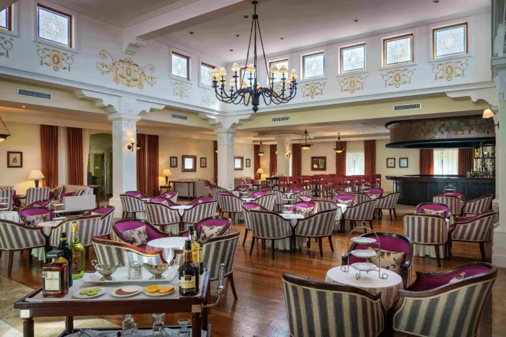 Don Miguel bar and lounge with striped seating and a large chandelier at Valentin Imperial, Riviera Maya