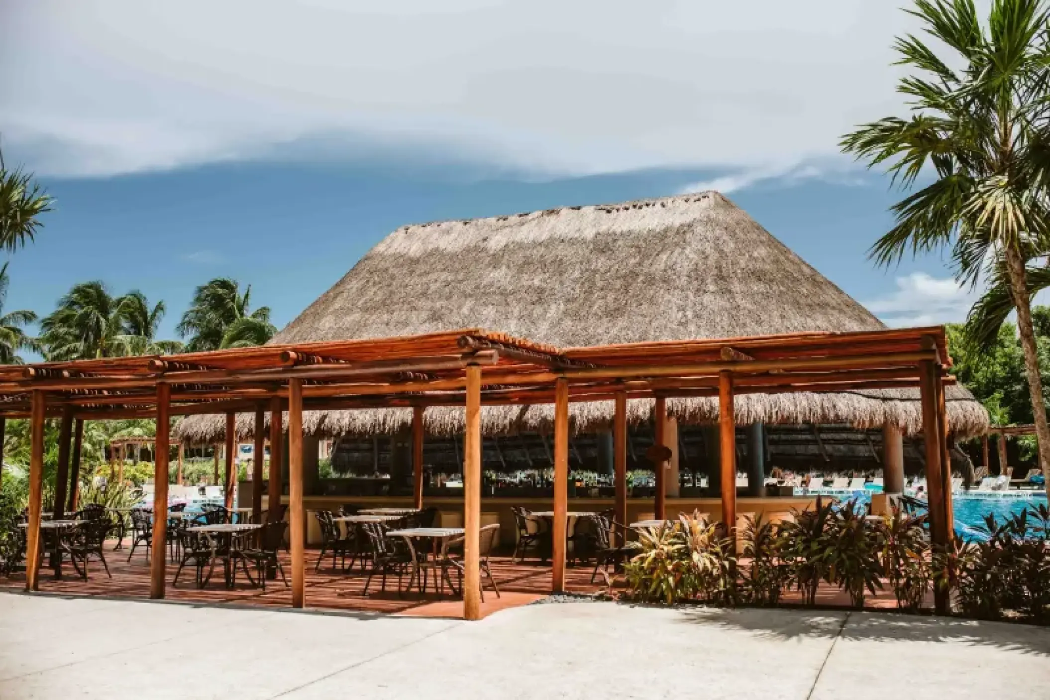 Valentin Imperial Riviera Maya open-air pool bar and terrace with thatched palapa roof