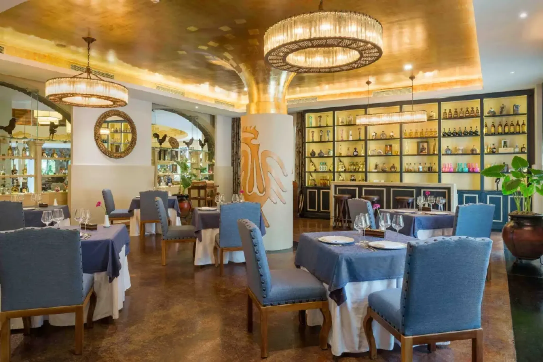 La Hacienda restaurant dining room with blue chairs and gold accents at Valentin Imperial, Riviera Maya