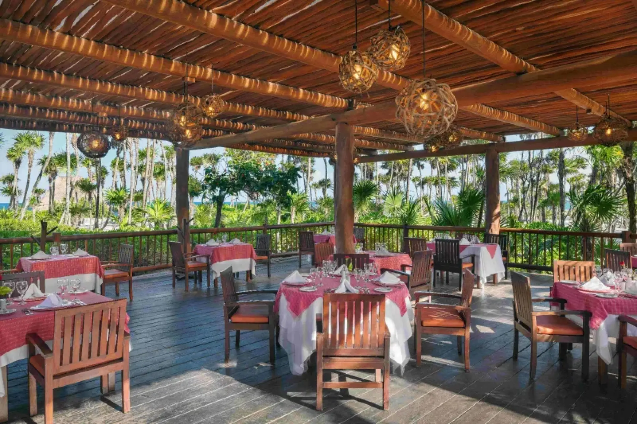 Mar y Tierra terrace dining area under a thatched roof at Valentin Imperial, Riviera Maya