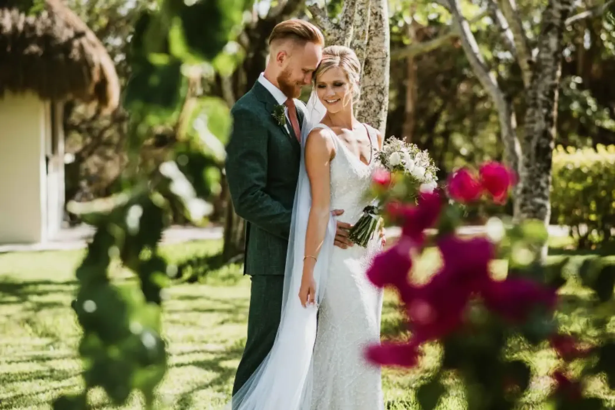 The couple posing in a garden for their Mayan wedding at Valentin Imperial, Riviera Maya