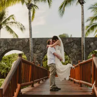 Groom lifting the bride on a wooden bridge at Valentin Imperial, Riviera Maya