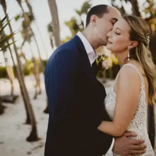 Groom kissing the bride's forehead during a wedding portrait at Valentin Imperial, Riviera Maya