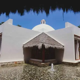 White wedding chapel with a palapa entrance at Valentin Imperial, Riviera Maya