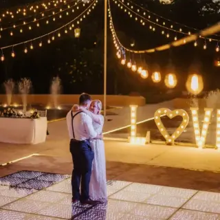 Couple dancing on a lit dance floor during a reception at Valentin Imperial, Riviera Maya