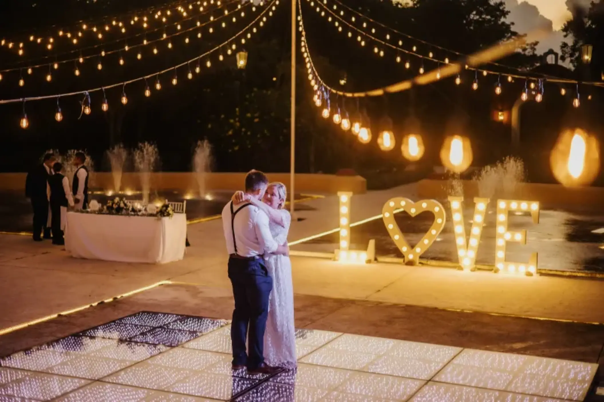 Couple dancing on a lit dance floor during a reception at Valentin Imperial, Riviera Maya