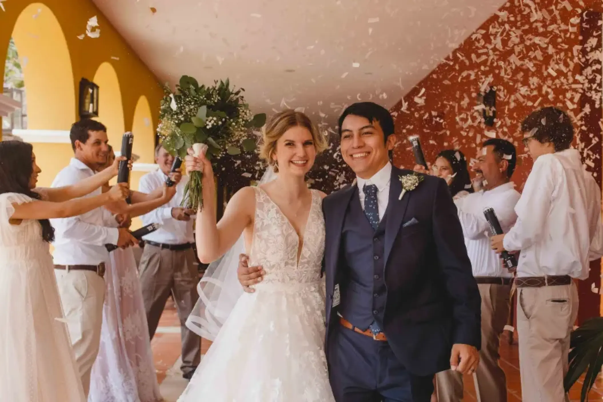 The bride and groom walking through confetti after their wedding ceremony at Valentin Imperial, Riviera Maya
