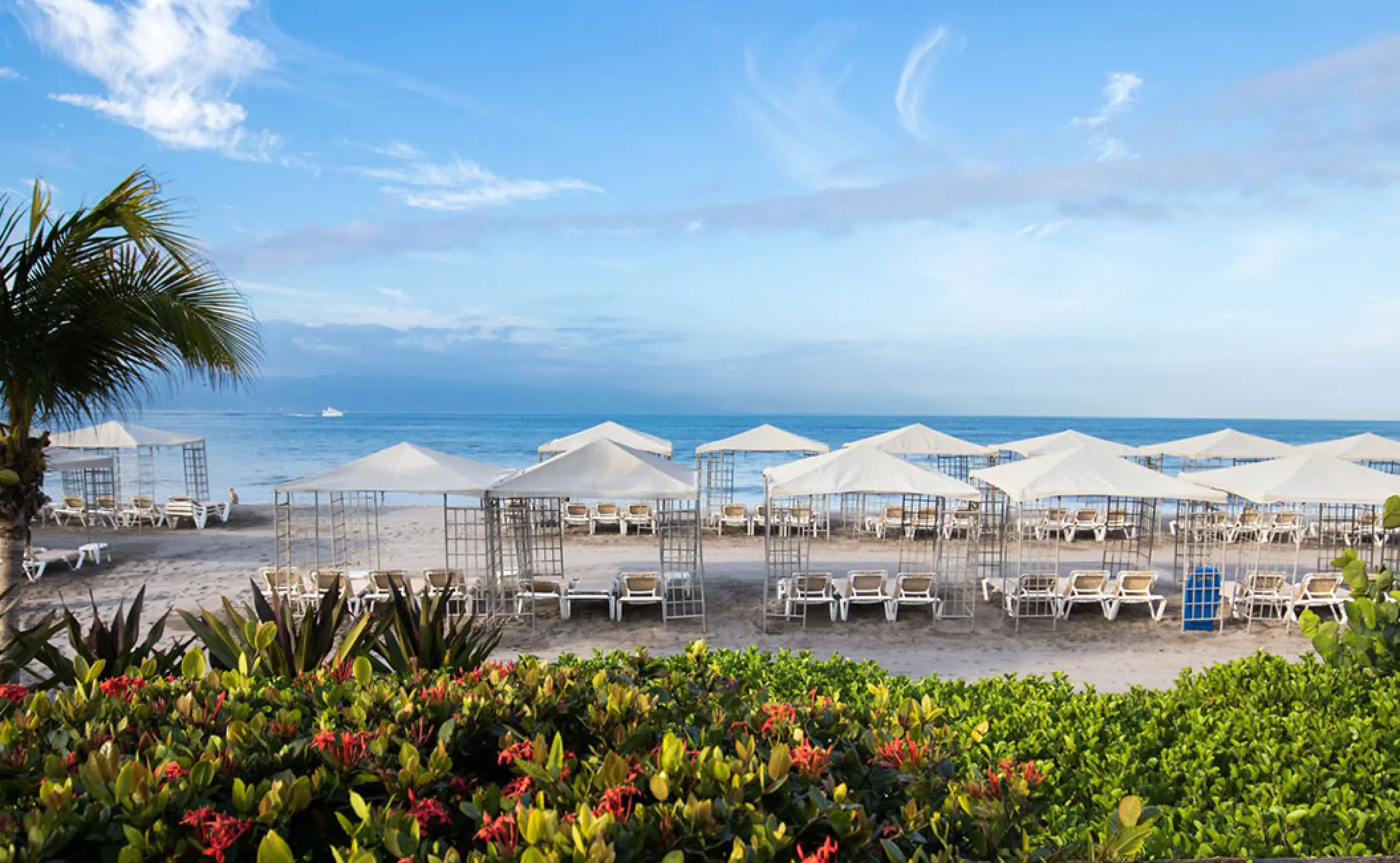 White cabanas and lounge chairs on the beach at Velas Vallarta, Puerto Vallarta