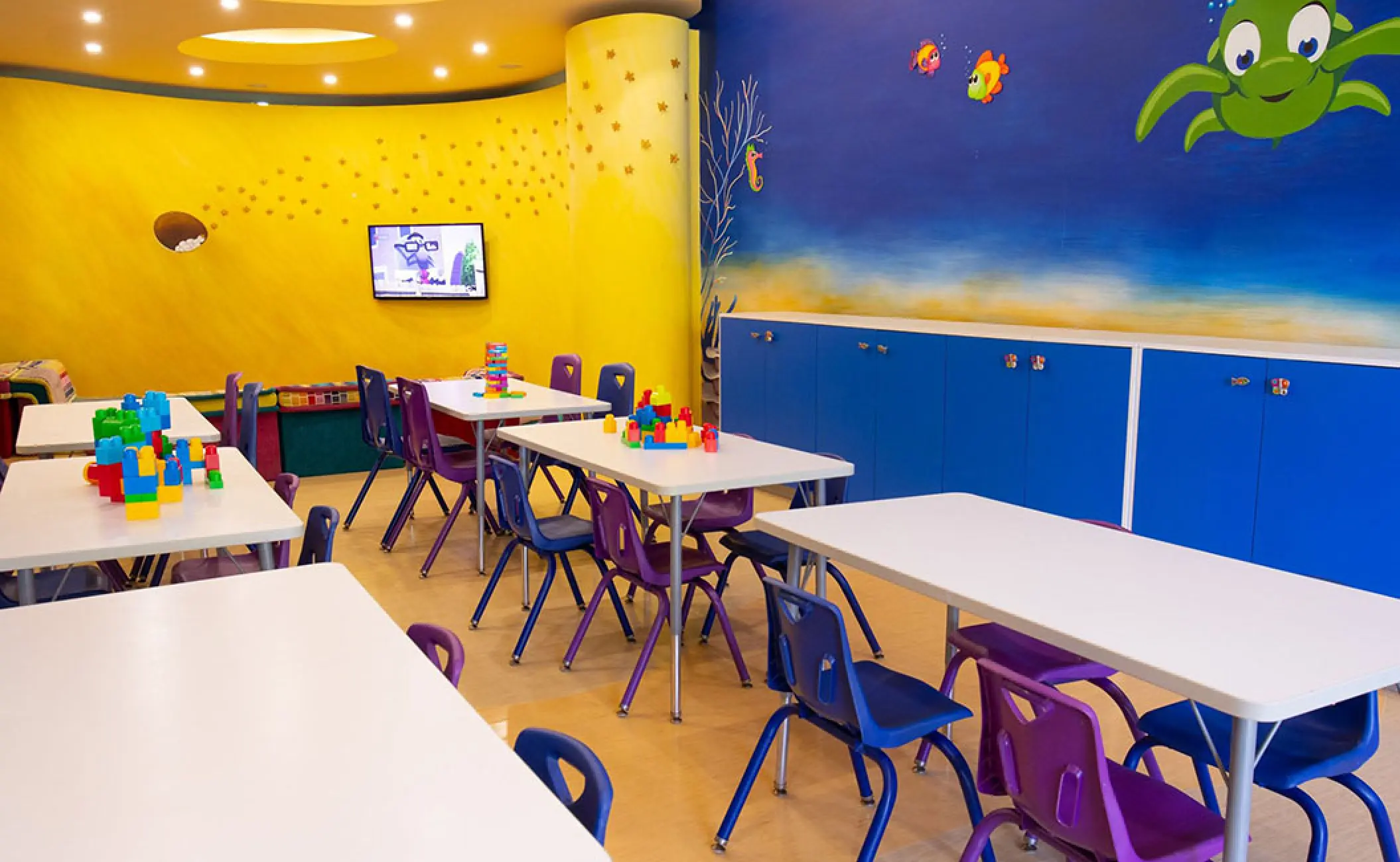 Kids club with colorful tables and ocean-themed wall murals at Velas Vallarta, Puerto Vallarta