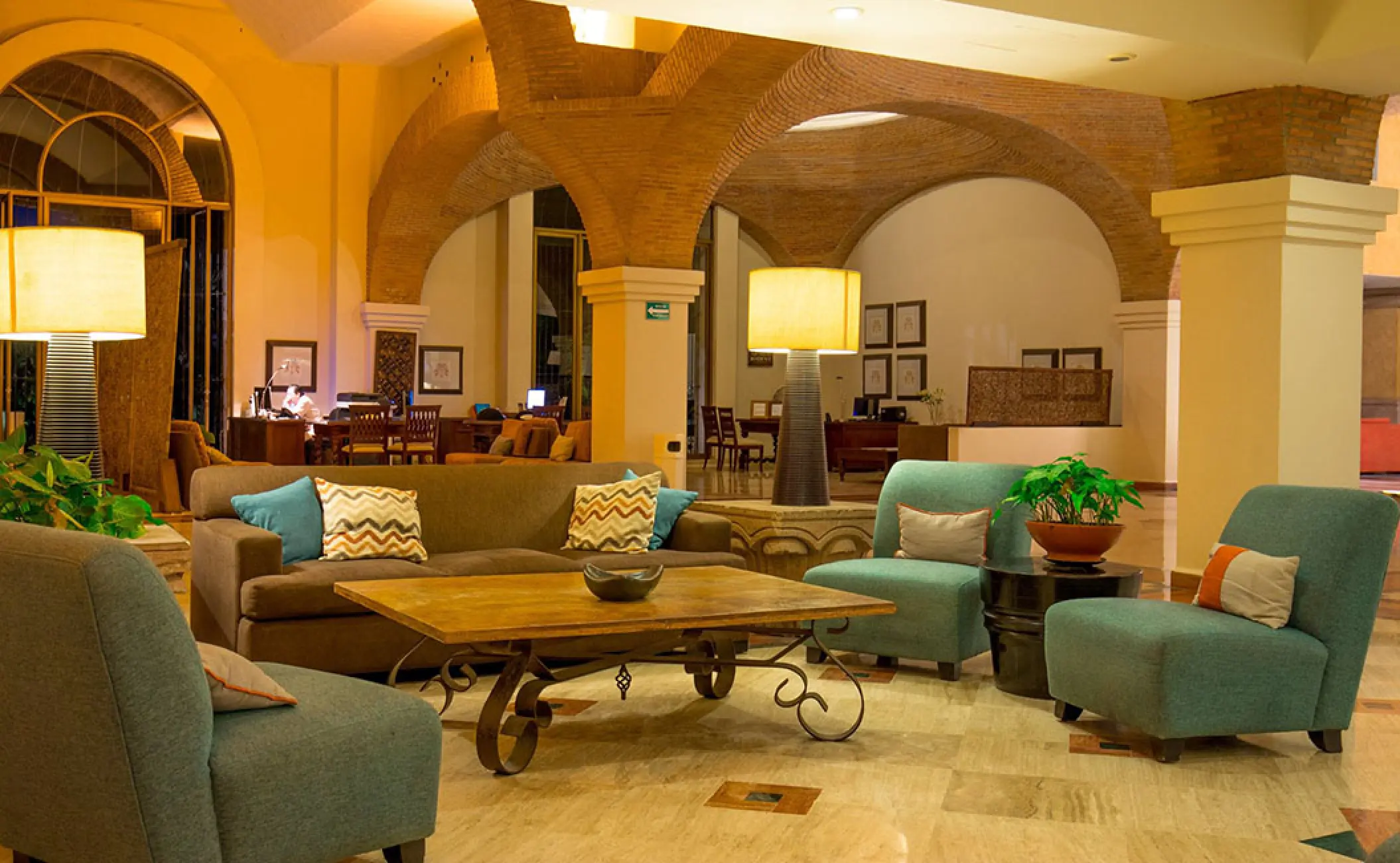 Spacious resort lobby sitting area with brick arches and colorful seating at Velas Vallarta, Puerto Vallarta