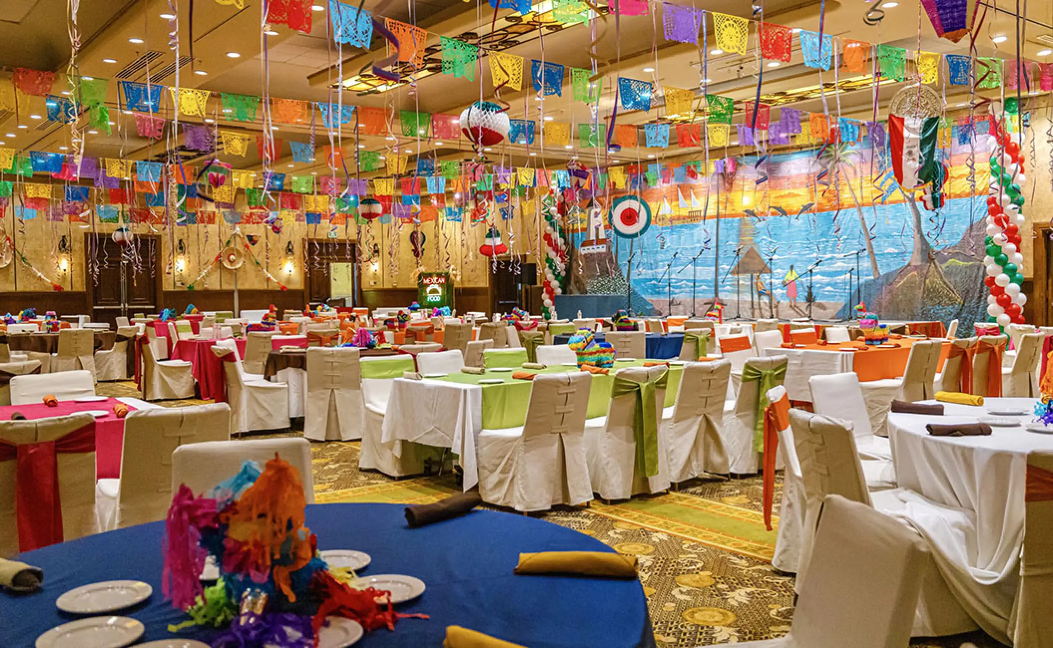 Mexican fiesta wedding reception with colorful papel picado banners at Velas Vallarta, Puerto Vallarta