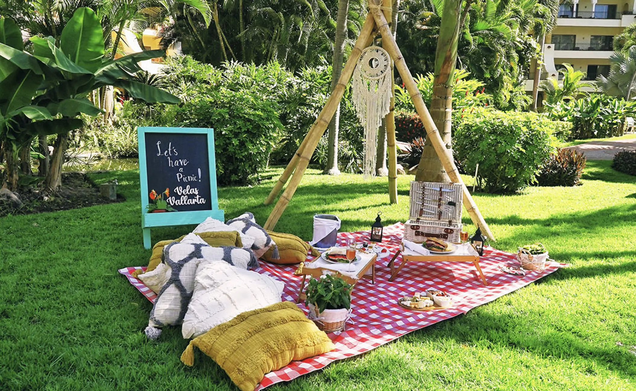 Boho picnic setup with a teepee and pillows on the lawn at Velas Vallarta, Puerto Vallarta