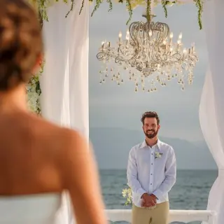 Groom waiting at the beach ceremony altar for his bride at Velas Vallarta, Puerto Vallarta
