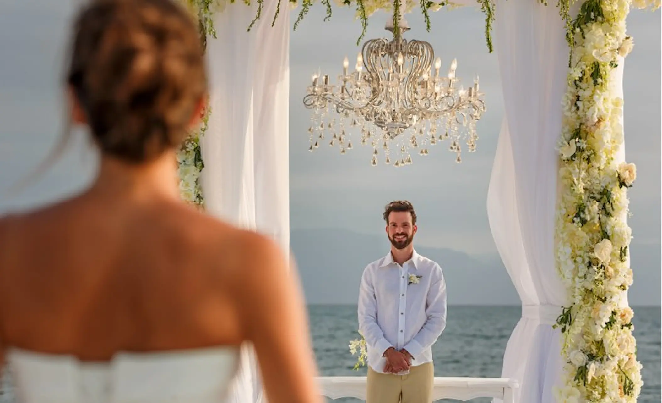 Groom waiting at the beach ceremony altar for his bride at Velas Vallarta, Puerto Vallarta