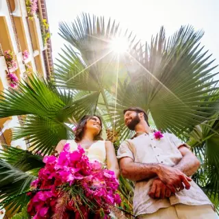 Low-angle portrait of a bride and groom under palm trees at Velas Vallarta, Puerto Vallarta