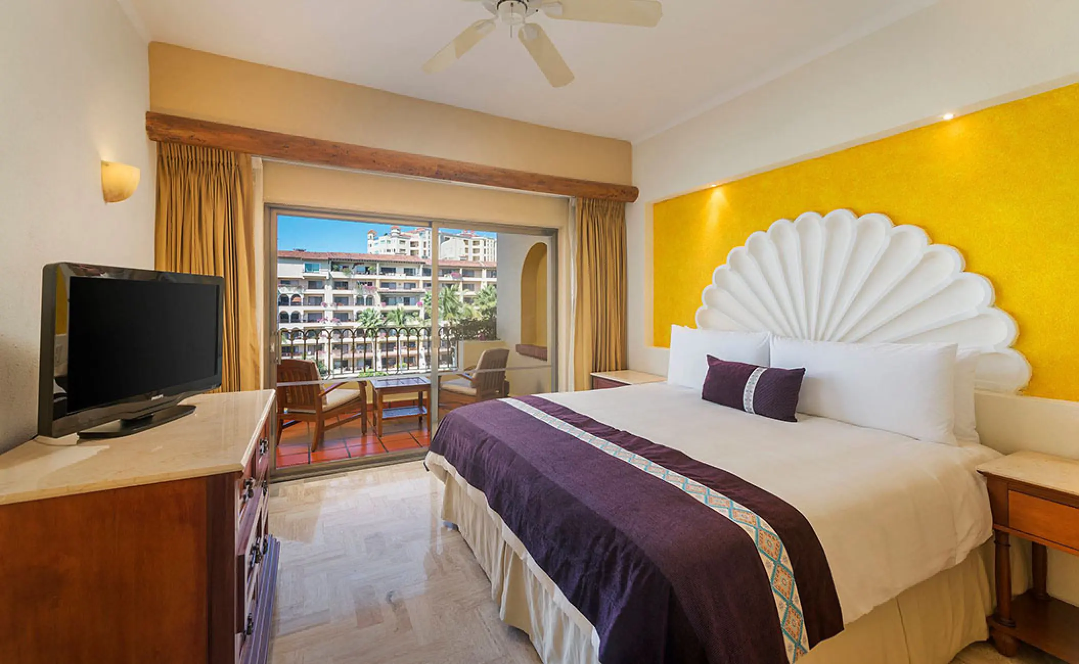 Deluxe suite bedroom with shell headboard and balcony at Velas Vallarta, Puerto Vallarta